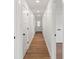 Hallway featuring hardwood floors, white trim, and doors with black hardware at 2429 Ellen Ave, Charlotte, NC 28208