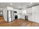 Open kitchen featuring stainless steel appliances, white cabinets, and hardwood floors at 2429 Ellen Ave, Charlotte, NC 28208