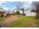 Large backyard with grass and partially exposed dirt, surrounded by fencing, featuring outbuildings at 306 W 2Nd St, Cherryville, NC 28021
