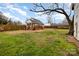 Backyard featuring deck, fencing, outbuilding, mature tree, and fire pit at 306 W 2Nd St, Cherryville, NC 28021