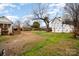 Large backyard with grass and partially exposed dirt, surrounded by fencing, featuring outbuildings at 306 W 2Nd St, Cherryville, NC 28021