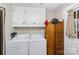 Functional laundry room with washer, dryer, white cabinetry, and convenient exterior access to the outdoors at 306 W 2Nd St, Cherryville, NC 28021