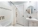 Bright bathroom featuring a pedestal sink, tiled shower with grab bar, and wainscoting at 331 Solomon St, Charlotte, NC 28216