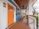 Inviting front porch features a wood ceiling, orange door, rocking chairs and white railing at 331 Solomon St, Charlotte, NC 28216