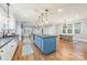 Bright, open-concept kitchen featuring a center island, stainless steel sink, and hardwood floors at 331 Solomon St, Charlotte, NC 28216