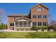 Exterior of brick home showcasing the backyard, the screened-in porch, landscaping, and patio at 409 Running Horse Ln, Waxhaw, NC 28173