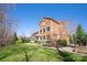 View of the brick home's backyard with lush green grass, mature trees, landscaping, and a fenced-in area at 409 Running Horse Ln, Waxhaw, NC 28173