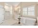 Serene bathroom featuring a soaking tub, glass shower, and marble countertops, offering a spa-like experience at 409 Running Horse Ln, Waxhaw, NC 28173