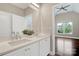 Bathroom with double sink vanity and view into bedroom with vaulted ceiling at 409 Running Horse Ln, Waxhaw, NC 28173