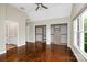 Spacious bedroom featuring hardwood floors, a ceiling fan, and walk-in closets with custom shelving at 409 Running Horse Ln, Waxhaw, NC 28173