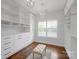 A very large closet with custom shelving, marble countertops, and elegant chandelier at 409 Running Horse Ln, Waxhaw, NC 28173