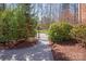 A charming stone walkway leads to a wrought iron gate surrounded by lush landscaping at 409 Running Horse Ln, Waxhaw, NC 28173