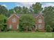 Charming two-story brick home with a well-manicured lawn and mature landscaping at 409 Running Horse Ln, Waxhaw, NC 28173