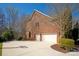 Spacious three-car garage with a basketball court and a large driveway on a sunny day at 409 Running Horse Ln, Waxhaw, NC 28173