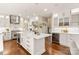 Spacious kitchen with stainless steel appliances, wine cooler, hardwood floors and white cabinets at 409 Running Horse Ln, Waxhaw, NC 28173