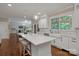 Open kitchen with a large island, hardwood floors, lots of cabinets and marble countertops at 409 Running Horse Ln, Waxhaw, NC 28173
