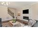 Living room showcasing a fireplace, tv, stairway and comfortable seating at 409 Running Horse Ln, Waxhaw, NC 28173