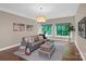 Inviting living room featuring a comfortable gray sofa, natural light, and unique decor at 409 Running Horse Ln, Waxhaw, NC 28173