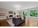 Open living room with hardwood floors, stone fireplace, large windows and comfortable seating at 409 Running Horse Ln, Waxhaw, NC 28173