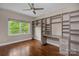 A office featuring custom shelving, hardwood floors, and a ceiling fan at 409 Running Horse Ln, Waxhaw, NC 28173