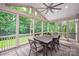 Screened porch with brick floor, ceiling fan, wood table and chairs, overlooking wooded backyard at 409 Running Horse Ln, Waxhaw, NC 28173