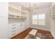 A spacious walk-in closet with custom built-ins, offering ample storage and organization, with chandeliers at 409 Running Horse Ln, Waxhaw, NC 28173