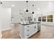 Bright kitchen features a center island with black countertop, stainless steel appliances, and hardwood floors at 412 W Westview St, Gastonia, NC 28052