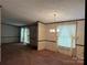 The open dining room featuring carpet floors, a chandelier, and a large window at 459 Towell St, Mooresville, NC 28115