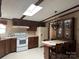 Eat-in kitchen featuring neutral countertops, dark cabinets, and a skylight at 459 Towell St, Mooresville, NC 28115