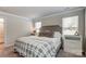 Bright main bedroom features a bed with a patterned blanket and two windows for natural light at 502 Tayberry Ln, Fort Mill, SC 29715
