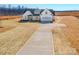 New construction, white farmhouse-style home featuring a large lot and a concrete driveway at 520 Shoal Rd, Lincolnton, NC 28092