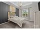 Well-lit bedroom featuring gray walls, a comfortable bed, and neutral carpet flooring at 824 Imperial Ct, Charlotte, NC 28273