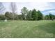 Expansive backyard featuring a lush lawn and mature trees, providing a serene outdoor space at 841 Wandering Way Dr, Waxhaw, NC 28173