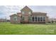 Rear view of home highlighting the brick exterior, deck, and screened porch overlooking the grassy yard at 841 Wandering Way Dr, Waxhaw, NC 28173