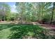 Backyard view showing lawn, landscaping, and a small foot bridge near the rear of the property at 9901 Strike The Gold Ln, Waxhaw, NC 28173