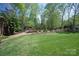 Beautifully landscaped backyard featuring a lush green lawn and wooded area, creating a private retreat at 9901 Strike The Gold Ln, Waxhaw, NC 28173
