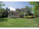 Stately brick home showcasing a well-manicured backyard, lush lawn, and covered patio at 9901 Strike The Gold Ln, Waxhaw, NC 28173