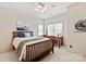 Bright bedroom showcasing natural light, ceiling fan, wooden bed frame, and small desk at 9901 Strike The Gold Ln, Waxhaw, NC 28173