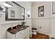 This powder room has beadboard walls, a cherry vanity, a bronze sink, and hardwood floors at 9901 Strike The Gold Ln, Waxhaw, NC 28173