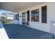 Inviting front porch featuring a blue deck, white railings, and matching black shutters on the light-colored home at 116 Garrison Dr, Belmont, NC 28012