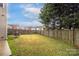 Spacious backyard with a well-maintained lawn, bordered by a wooden fence and mature trees for privacy at 128 Lacona Trce, Mooresville, NC 28115