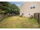 Large backyard features a lush lawn, bordered by a wooden fence and mature trees, offering serene outdoor space at 128 Lacona Trce, Mooresville, NC 28115