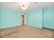 Spacious bedroom with carpet, seafoam walls, and a ceiling fan for comfort at 128 Lacona Trce, Mooresville, NC 28115