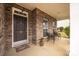 Inviting front porch features brick accents, an elegant entry door, and a cozy seating area for relaxing outdoors at 128 Lacona Trce, Mooresville, NC 28115