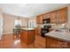 Well-lit kitchen with a center island, wooden cabinets, and hardwood flooring at 128 Lacona Trce, Mooresville, NC 28115