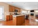 Kitchen with a functional island, wooden cabinets, and modern appliances on hardwood floor at 128 Lacona Trce, Mooresville, NC 28115