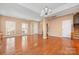 Bright living room with wood floors, neutral wall paint, open layout, and natural lighting streaming in from large windows at 128 Lacona Trce, Mooresville, NC 28115
