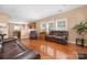 Open-concept living room with hardwood floors, neutral paint, fireplace and comfortable leather sofas at 128 Lacona Trce, Mooresville, NC 28115