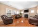Inviting living room features a fireplace, hardwood floors, and comfortable leather seating at 128 Lacona Trce, Mooresville, NC 28115