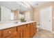 Main bathroom boasts double sinks, warm wood cabinets and flooring, and neutral walls at 128 Lacona Trce, Mooresville, NC 28115